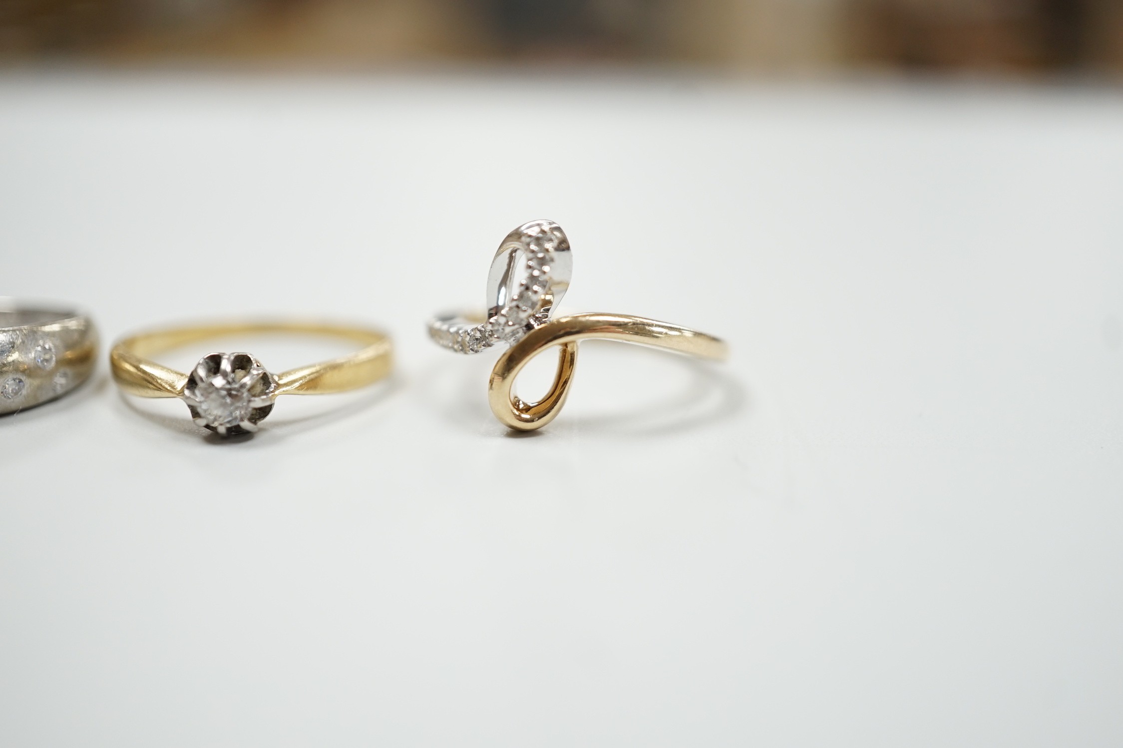 Three modern 9ct gold and diamond chip set rings and a yellow metal and solitaire diamond set ring, gross weight 12.4 grams.